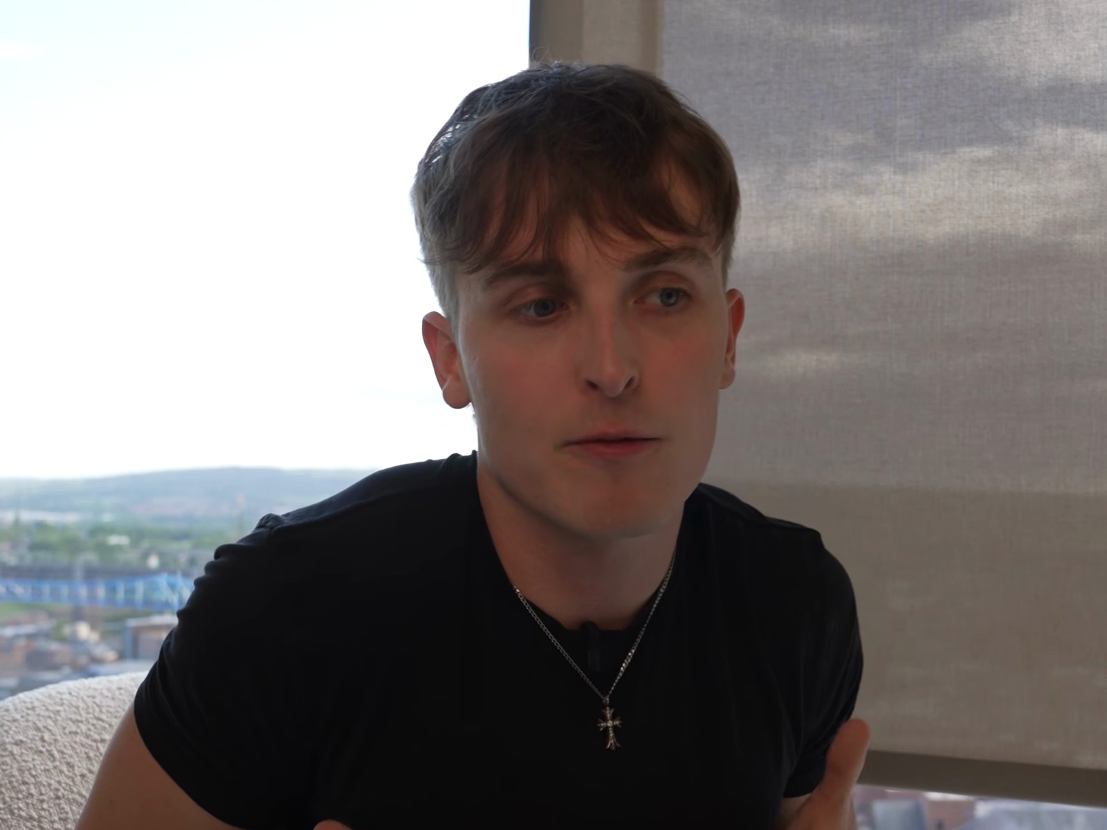 Jake Trinder seated by a window above the Newcastle skyline